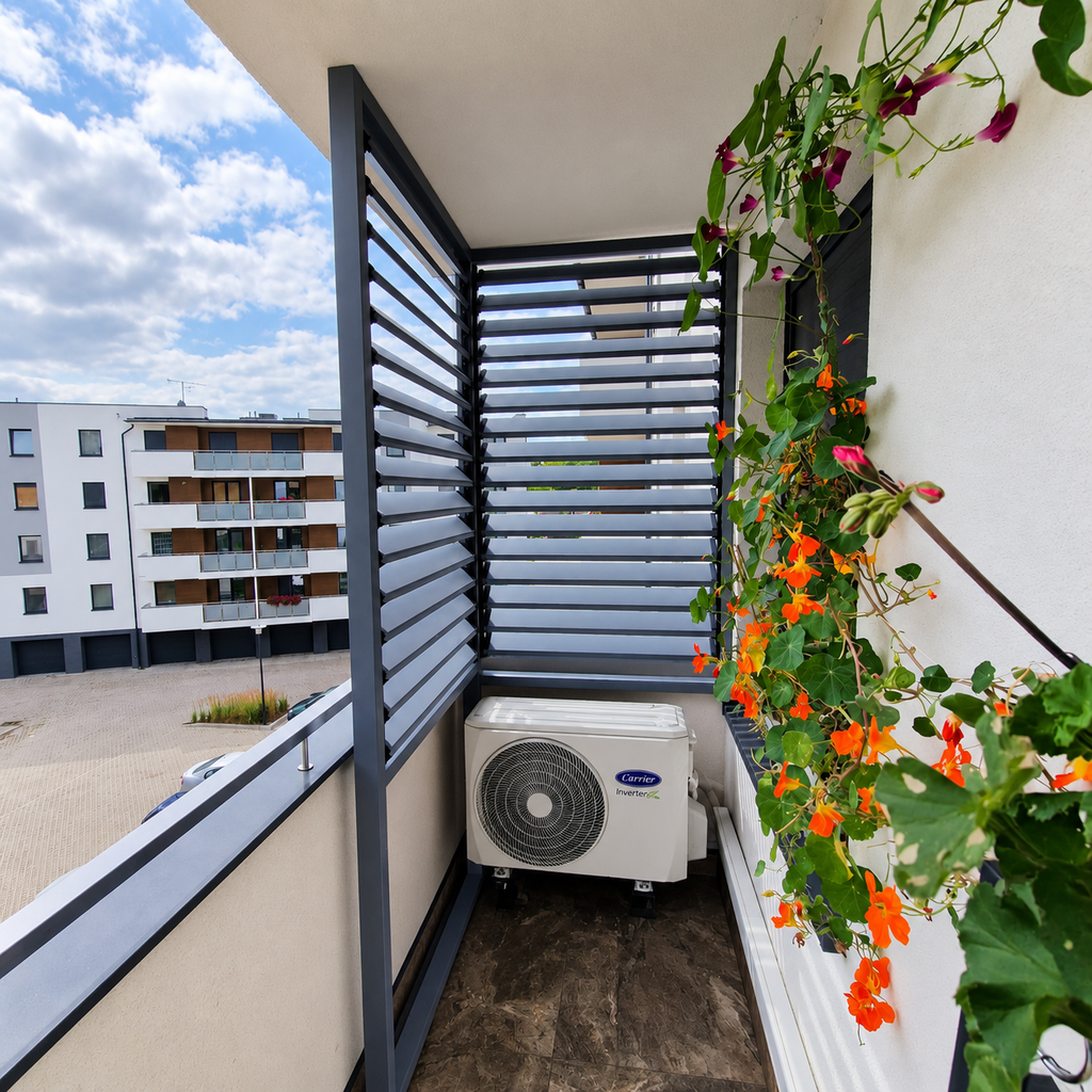Balcony enclosure in a block of flats; a fixed L-shaped enclosure with OpenUp System retractable patio blinds