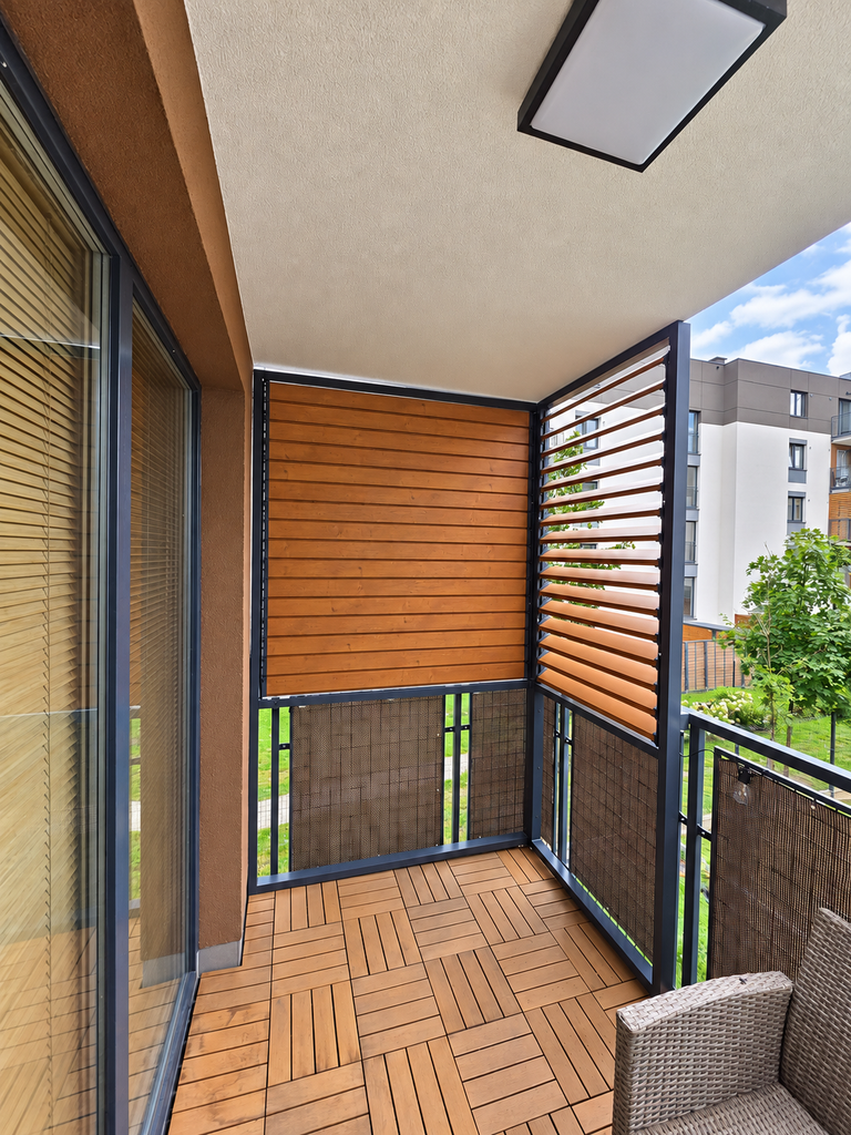 Balcony enclosure in a block of flats; a fixed L-shaped enclosure with OpenUp System retractable patio blinds
